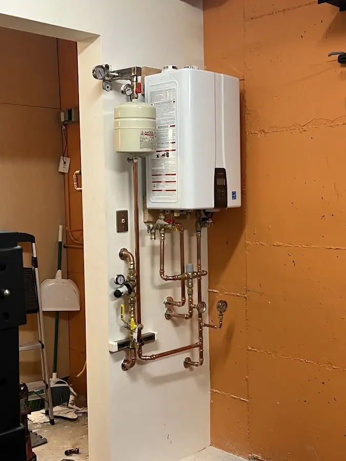 Plumbing technician inspecting water heater connections in Laurens